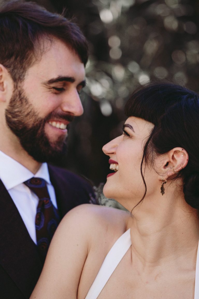 Un couple souriant, se regardant tendrement lors d'une célébration.