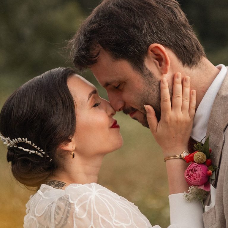 Un couple se dévoue dans une étreinte romantique lors de leur mariage.